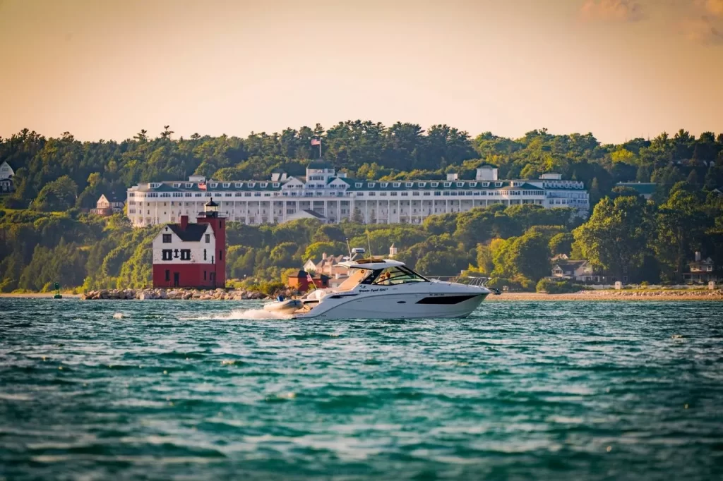 Brown Eyed Girl Boat Charter, a new boat charter service on Mackinac Island, is seen here on the Straits of Mackinac with Round Island Lighthouse and Grand Hotel in the background.