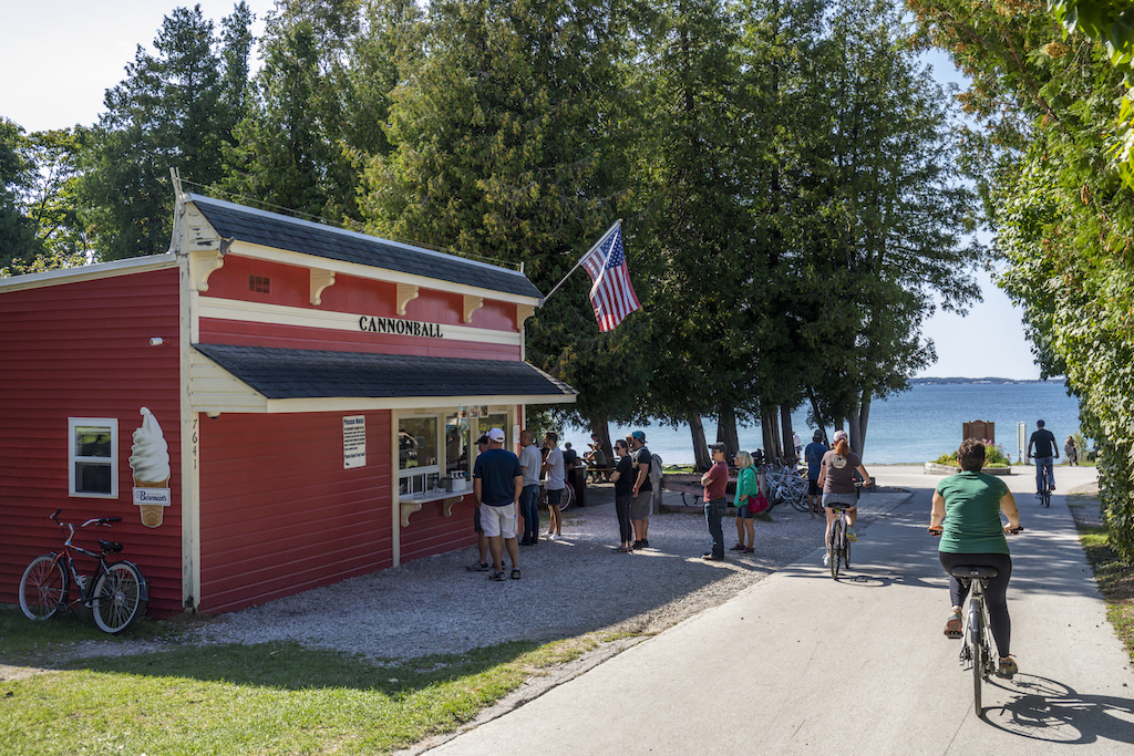 Customers wait in line outside Cannonball Oasis on Mackinac Island at British Landing