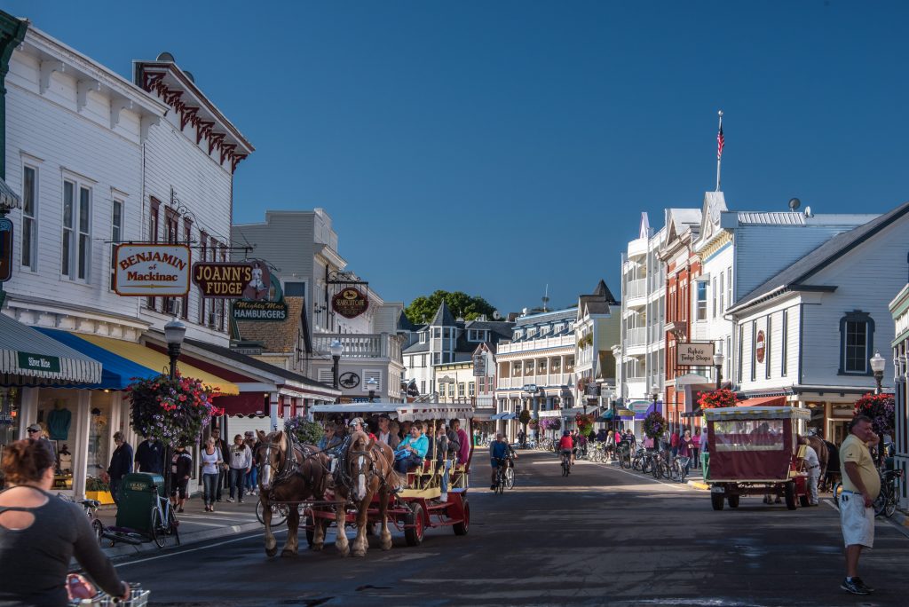 A narrated horse-drawn carriage tour on Mackinac Island makes its way down Main Street.