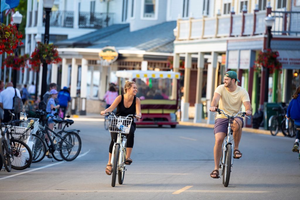 A young couple rides bikes on Mackinac Island's Main Street