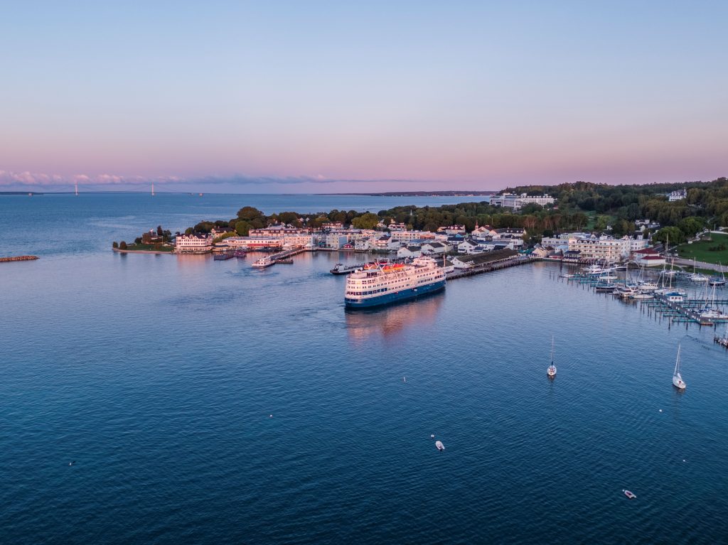 Aerial view of a Great Lakes cruise ship docking on Mackinac Island in the twilight of sunset