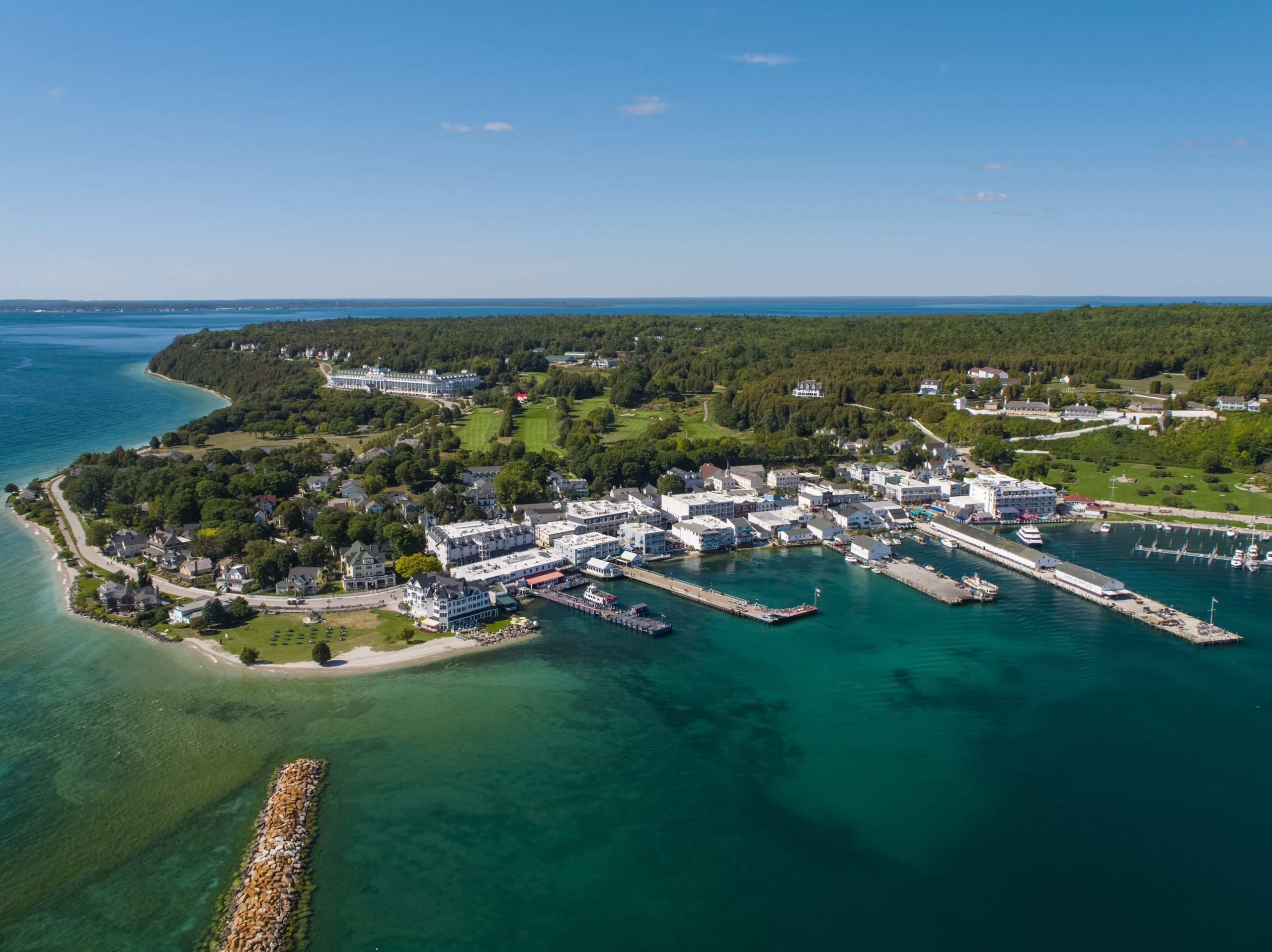 A drone image of Mackinac Island shows the ferry docks, downtown buildings and Grand Hotel and Fort Mackinac on the bluff.