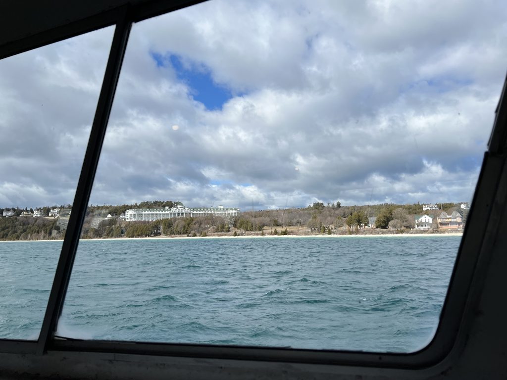 Mackinac Island’s Grand Hotel seen through the window of a passing ferry boat in early spring before the trees have leaves