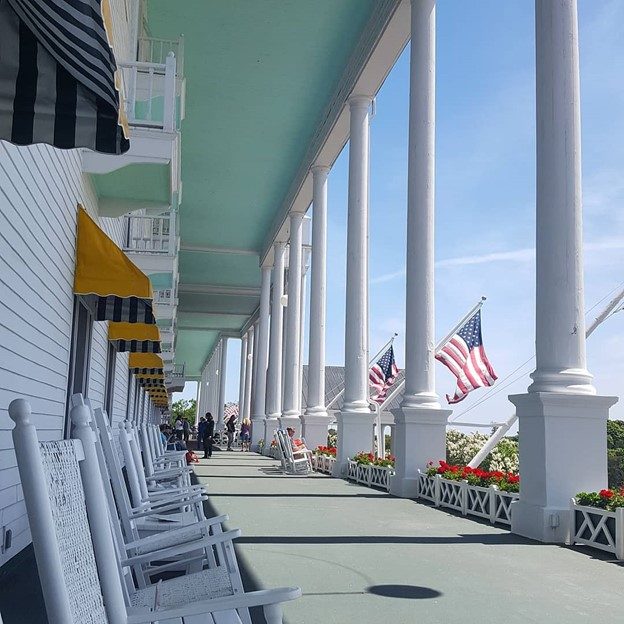 Adirondack chairs, giant pillars and American flags line the world’s longest front porch at Mackinac Island’s Grand Hotel