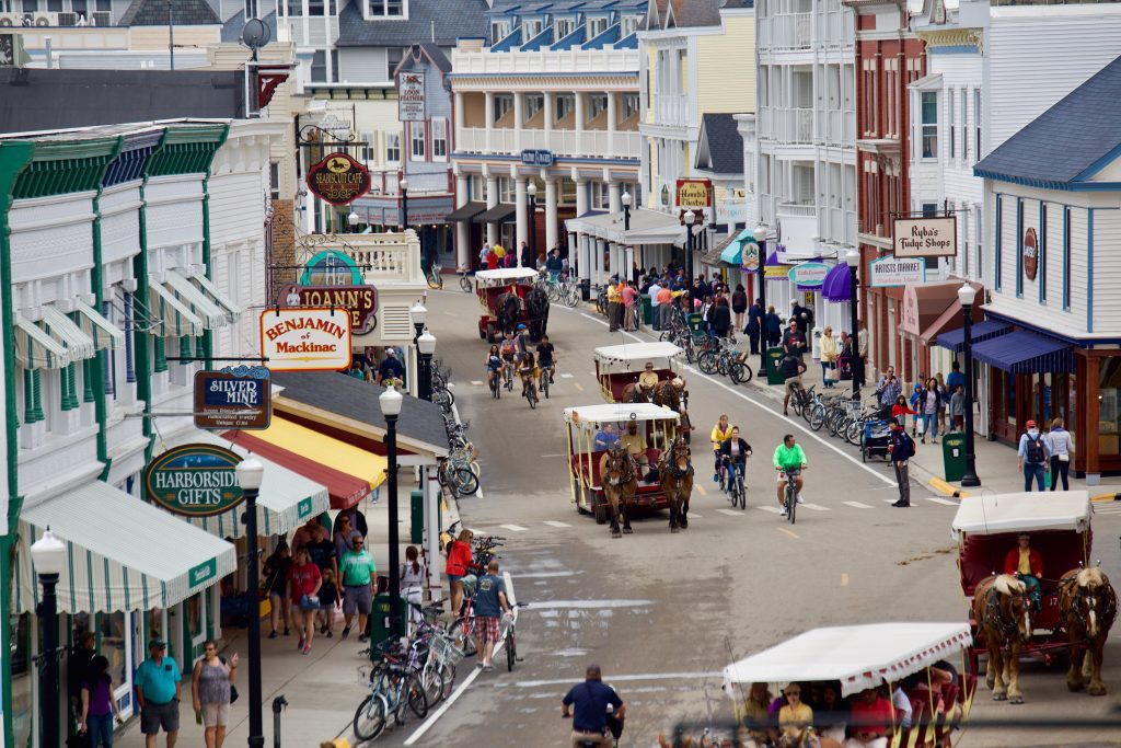 Pedestrians, bicycles and horse-drawn carriages make their way down Main Street in downtown Mackinac Island