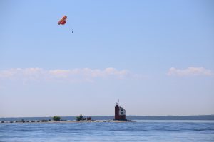 A parasailor floats high above Round Island Lighthouse off the coast of Michigan's Mackinac Island