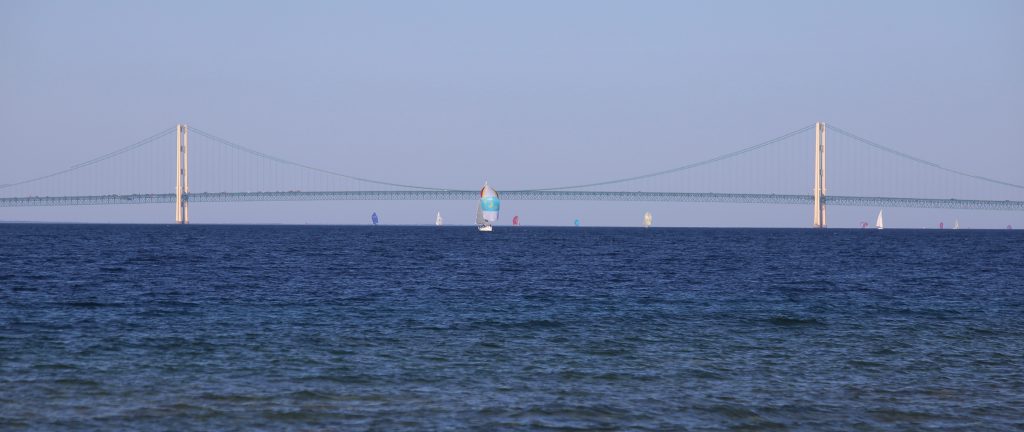 Yachts sail past the Mackinac Bridge on the way to Mackinac Island during one of the annual boat races
