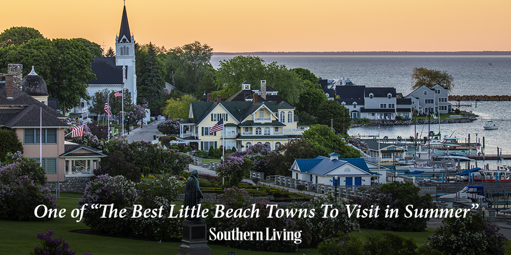 Eastward perspective of Mackinac Island's Main Street from Marquette Park with lilacs blooming and the words "One of 'The Best Little Beach Towns to Visit in Summer' - Southern Living"
