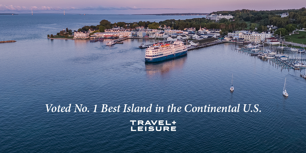 An aerial view of the Mackinac Island harbor with the words "Voted No.1 Best Island in the Continental U.S. - Travel + Leisure"