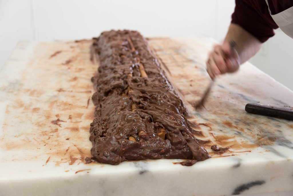 A Mackinac Island fudgemakers works a gooey mass of chocolate into a solid loaf of fudge
