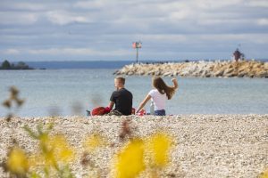 A young couple enjoys a picnic while relaxing on a rocky beach on Michigan’s Mackinac Island.