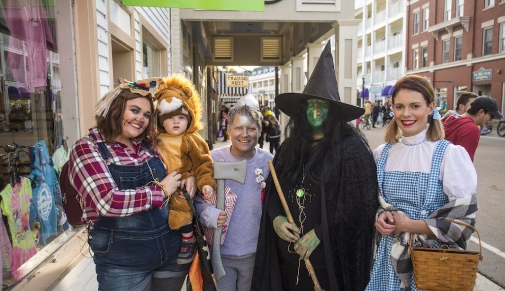 A group of people pose for a photo while wearing costumes during Mackinac Island's Halloween Weekend