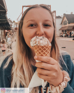 A young woman enjoys a waffle cone full of Mackinac Island Fudge ice cream while in downtown Mackinac Island