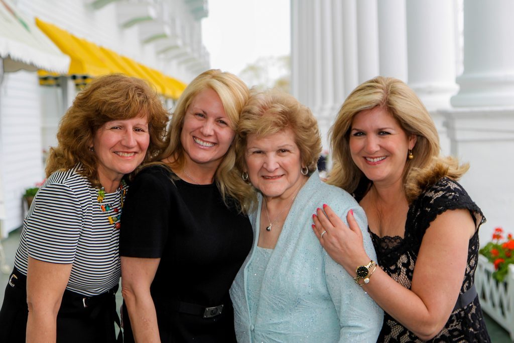Four women pose for the camera on the front porch of Mackinac Island's Grand Hotel