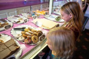 Two young girls look wide eyed at the sweets inside a display case at a Mackinac Island fudge shop