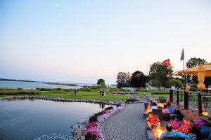 A fire lights up a table at Mission Point Resort's Bistro on the Greens as people play putt putt golf at sunset on Mackinac Island