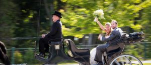 A happy bride and groom share a horse-drawn carriage ride after their Mackinac Island wedding ceremony