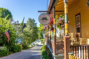 A Pine Cottage Bed & Breakfast sign hangs on the wraparound porch at the B&B on Mackinac Island’s Bogan Lane.