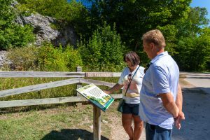 A couple reads a sign at Skull Cave, one of the most visited rock formations on Mackinac Island