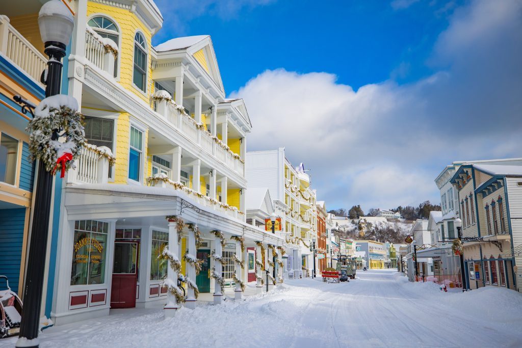 The sun shines on a row of Main Street buildings in downtown Mackinac Island on a quiet and snowy winter day