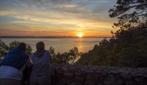A couple watches the sunset on Mackinac Island, enjoying one of the many perks of an overnight stay.