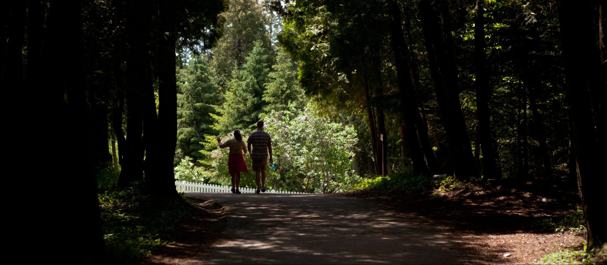 A couple walks along a wooded trail on Mackinac Island