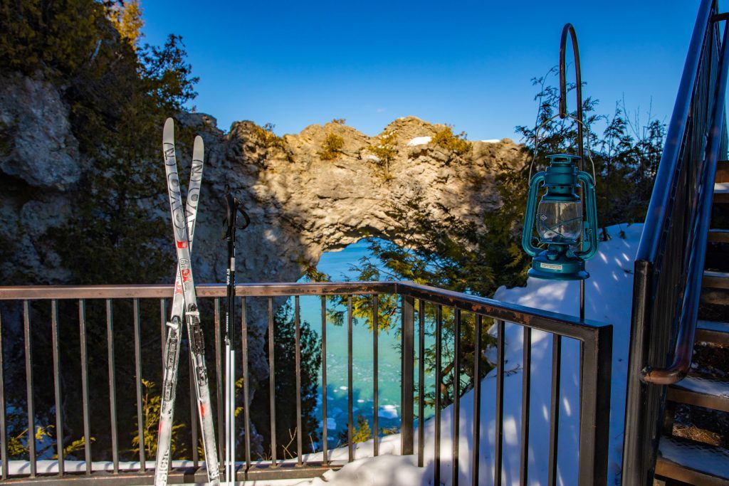 A pair of cross-country skis rest against the railing at Mackinac Island's iconic Arch Rock overlook