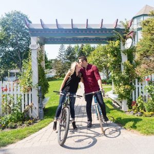 Couple Biking Under Arch – Mackinac Island Tourism Bureau 