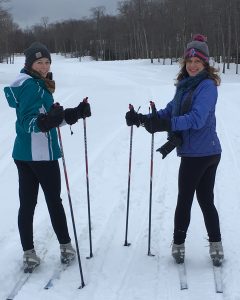 Two Women with Skis Enjoying Posing for Photo During Winter on Mackinac Island