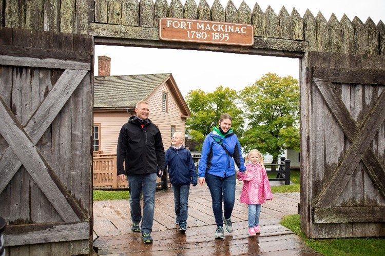 A smiling family exits Mackinac Island’s historic Fort Mackinac after a day of interactive fun and learning.