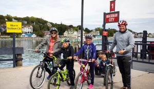 A family visiting Mackinac Island prepares for a bike ride after unloading their equipment from the ferry boat.