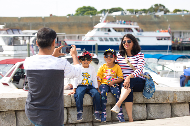 A family poses for a portrait in the Mackinac Island marina that overlooks the Mackinac Island harbor and ferry docks. 