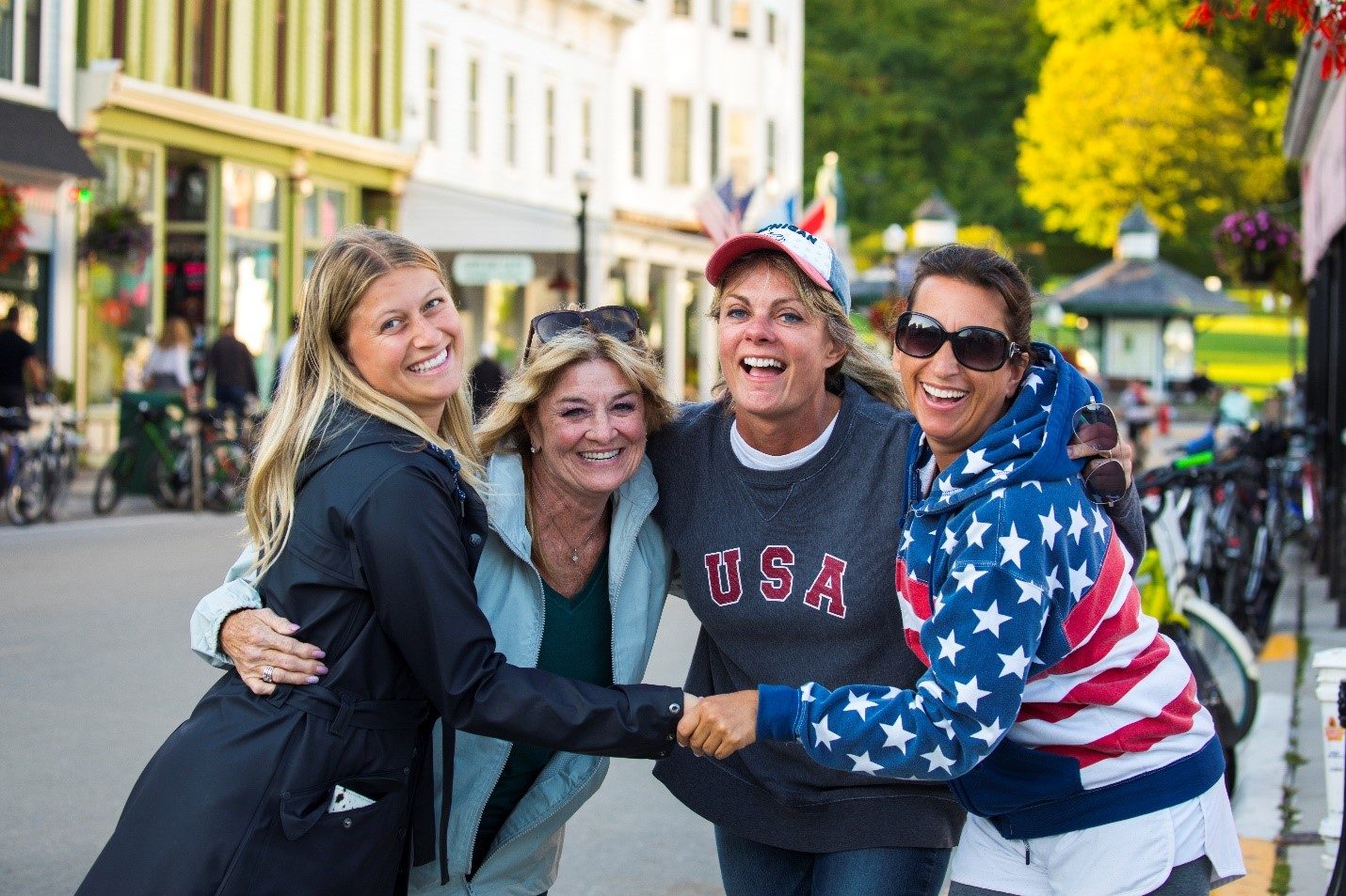 A group of women pose for a photo on Main Street while enjoying a Girls’ Weekend on Mackinac Island.