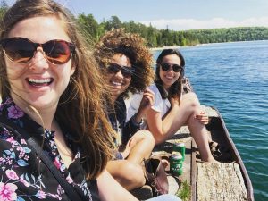 Three Female Friends Taking a Selfie With Drinks While Sitting on Dock On Mackinac Island