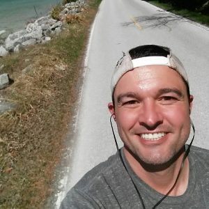 Runner Wearing Backwards Baseball Cap Taking a Selfie During Run Along Mackinac Island 