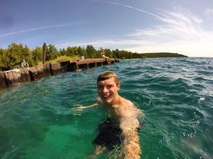 A man takes a selfie while swimming off the beach on Michigan’s Mackinac Island.