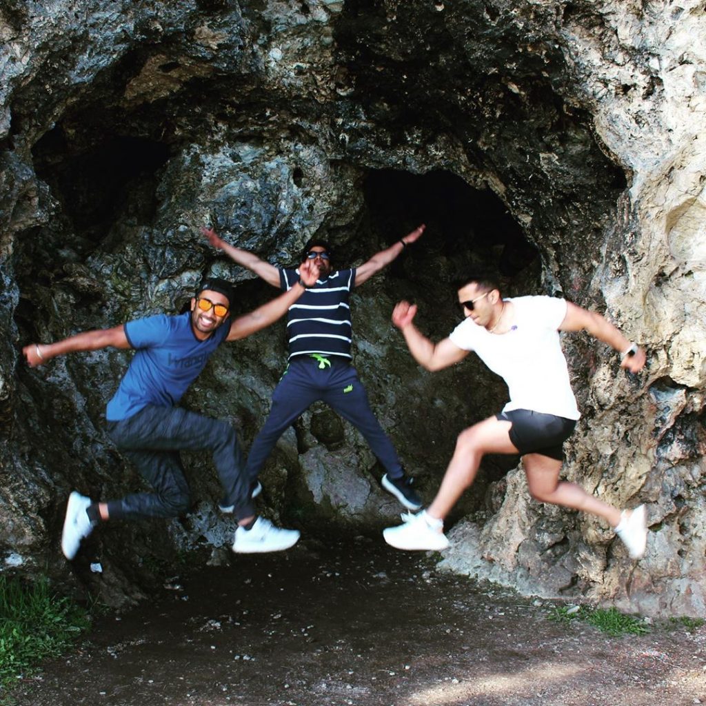 Three Young Men Playing Energetically in Cave on Mackinac Island 