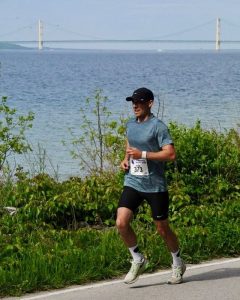 Runner Wearing Cap and Shorts Enjoying a Jog Along the Side of the Road on Mackinac Island