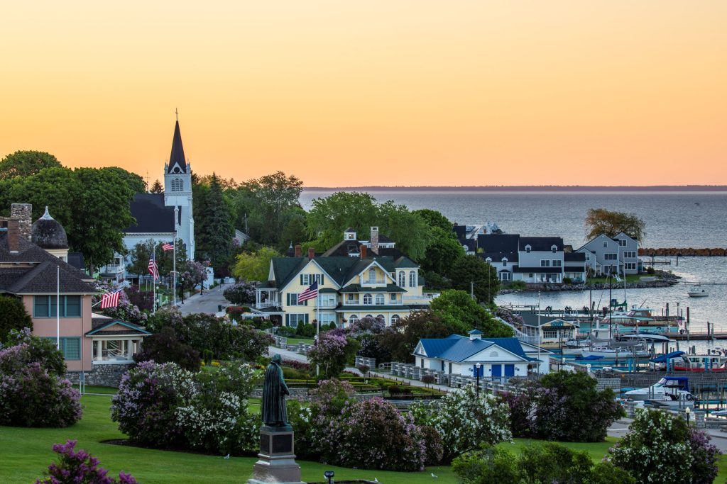 The sun rises over Mackinac Island beyond Marquette Park and Ste. Anne's Church