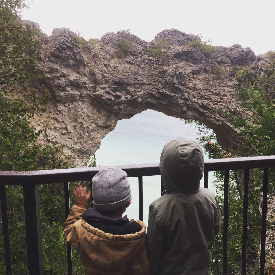 Two boys look over the railing at Mackinac Island's iconic Arch Rock